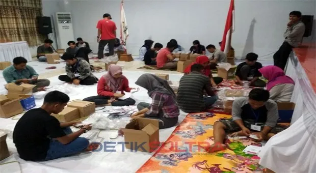 Foto warga sedang melipat surat suara