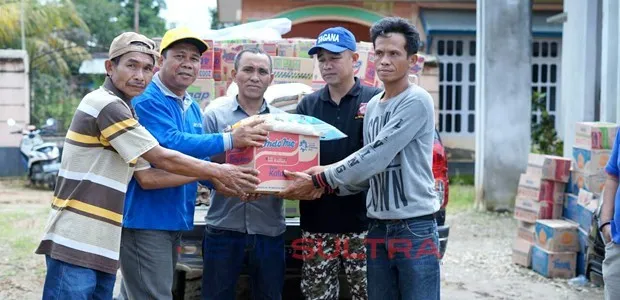 Umar Yahya saat menyerahkan bantuan logistik secara simbolis kepada Camat Mowewe (tengah) di posko banjir.