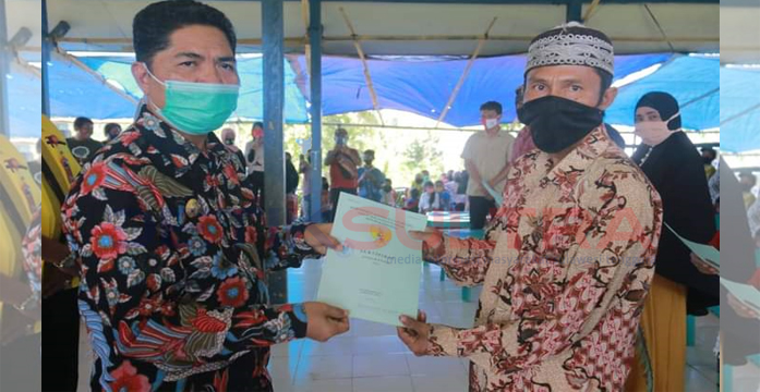 Bupati Buton, La Bakry, menyerahkan sertifikat tanah kepada warga Desa Rejosari. Lhia